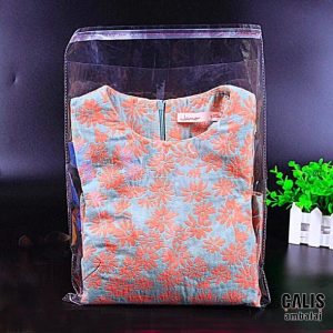 İçinde tekstil ürünü olan kenar dikiş kesimli bantlı baskısız OPP poşet.